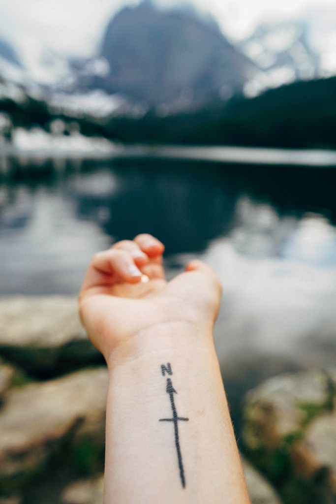 True North tattoo on wrist points over lake